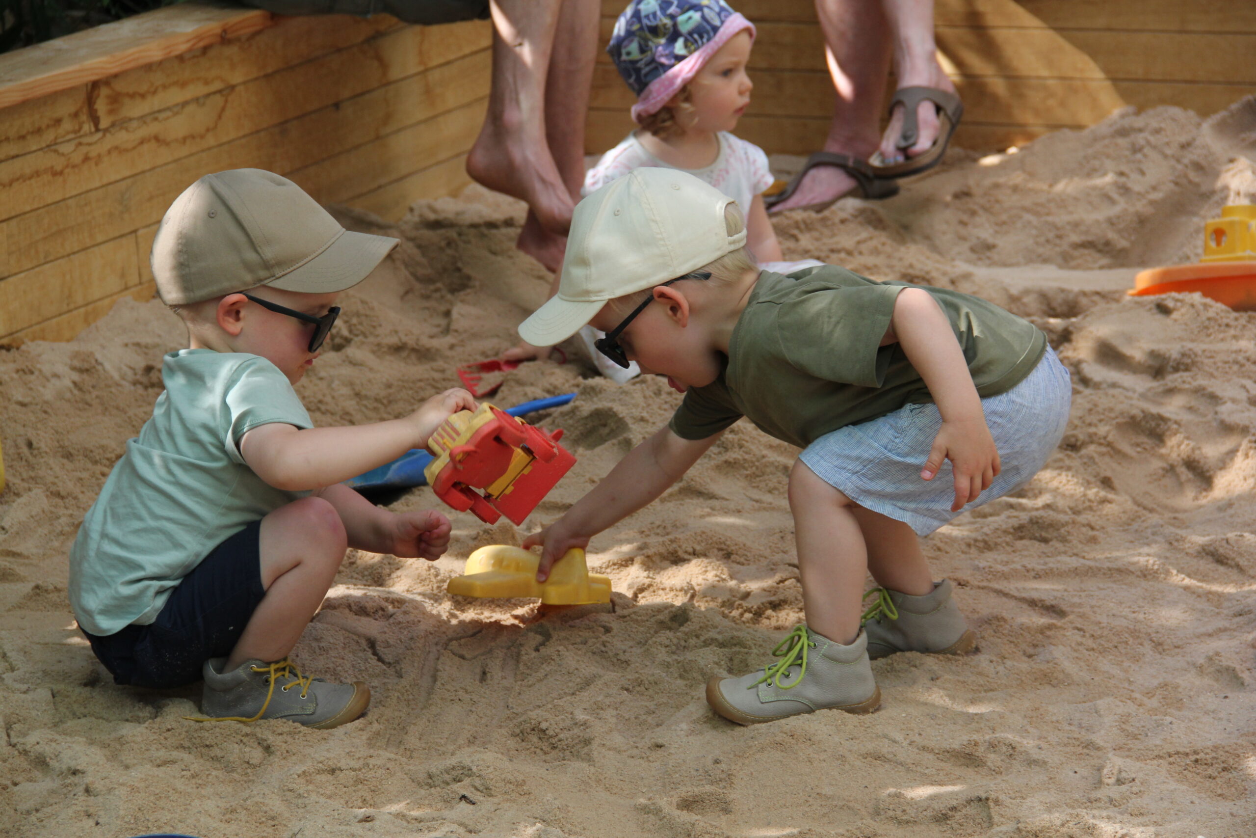 Kinder spielen im neuen Sandkasten.